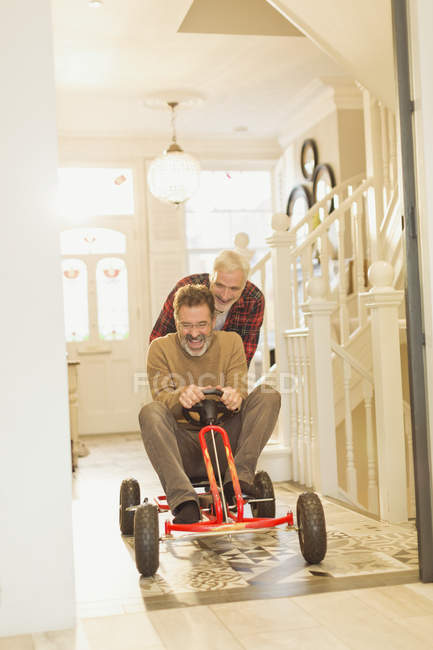 Brincalhão masculino gay casal jogar com brinquedo carro no foyer corredor — Fotografia de Stock