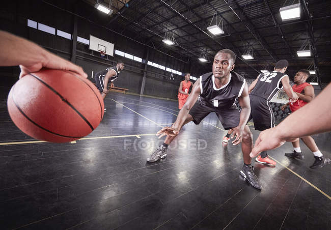 Jóvenes jugadores de baloncesto jugando en la cancha en el gimnasio - foto de stock