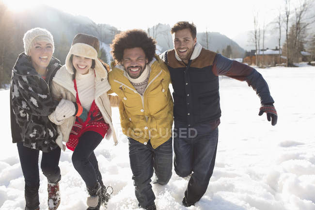 Amis courant dans la neige — Photo de stock