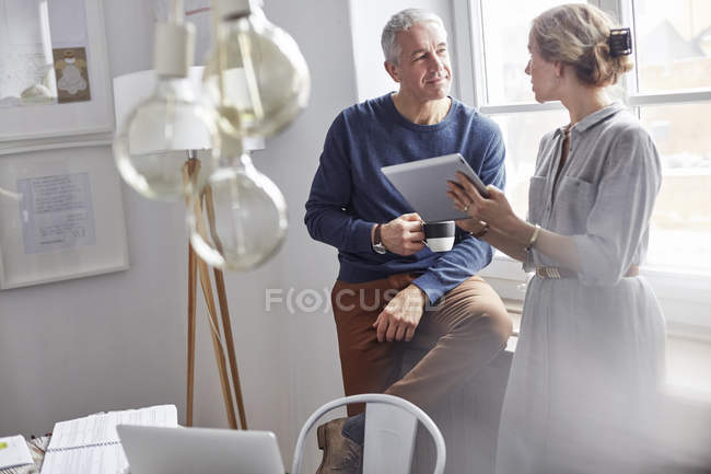 Business people drinking coffee and using digital tablet in office meeting — Stock Photo