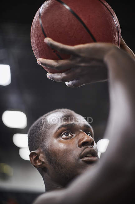 Close up focado jovem jogador de basquete masculino atirando a bola — Fotografia de Stock