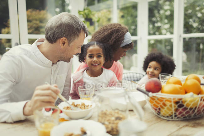 Retrato sorrindo multi-étnico jovem família tomando café da manhã à mesa — Fotografia de Stock
