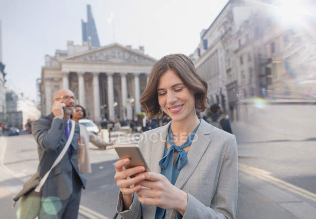 Geschäftsfrau SMS mit Handy auf der städtischen Straße, London, Großbritannien — Stockfoto