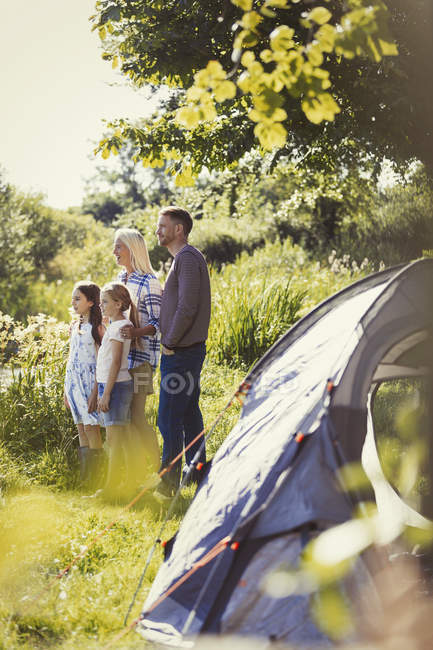 Семья, стоящая в солнечной палатке — стоковое фото