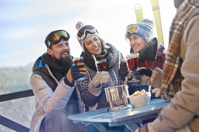 Skier friends drinking and eating at balcony table apres-ski — Stock Photo