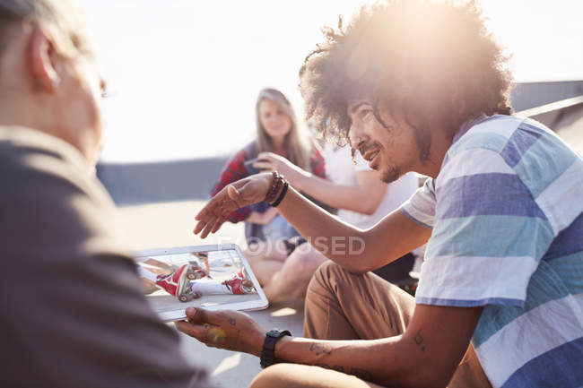 Freunde nutzen digitales Tablet im sonnigen Skatepark — Stockfoto