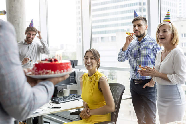 Деловые люди празднуют день рождения с тортом в офисе — стоковое фото