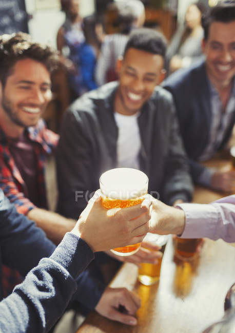 Camarero entregando cerveza al hombre en el bar - foto de stock