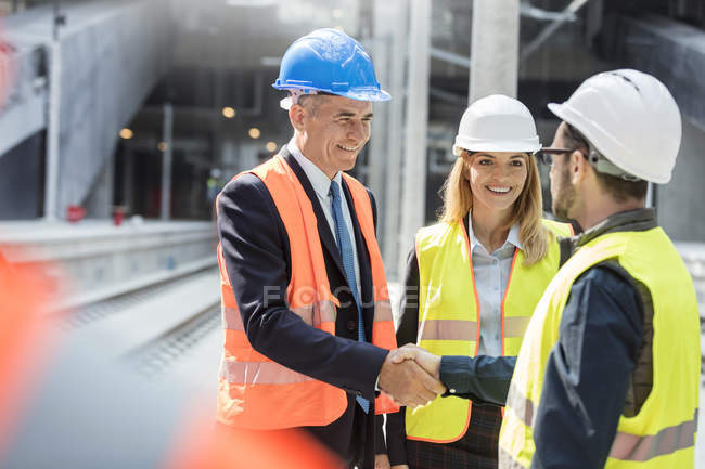 Businessman and engineer handshaking at construction site — Stock Photo
