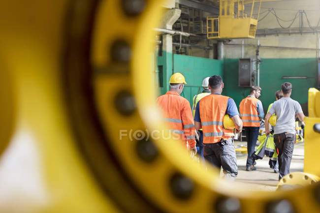 Vue arrière des travailleurs de l'acier marchant dans l'usine — Photo de stock