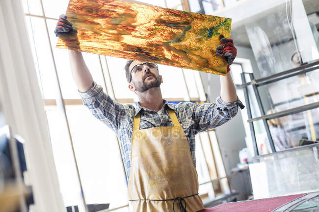 Künstler untersucht Glasmalerei im Atelier — Stockfoto