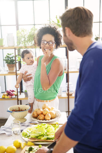 Glückliche Familie bereitet Mahlzeit in der heimischen Küche zu — Stockfoto
