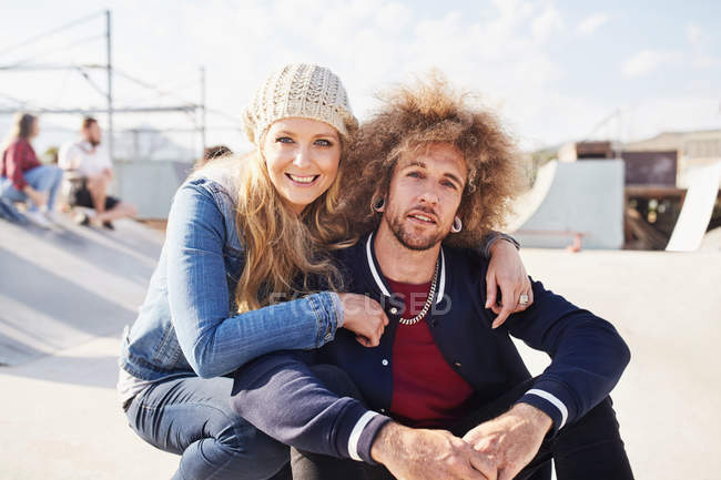 Retrato casal sorridente no ensolarado parque de skate — Fotografia de Stock