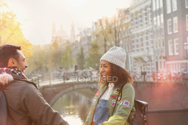 Parejas jóvenes en el puente urbano de otoño sobre el canal, Amsterdam - foto de stock