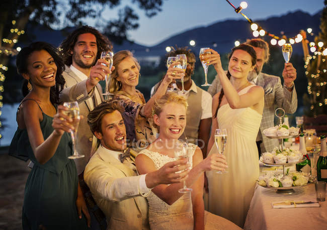 Hochzeitsgäste stoßen bei Hochzeitsempfang im Garten mit Champagner an — Stockfoto