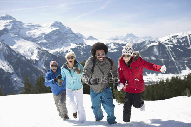 Freunde laufen im Schnee — Stockfoto
