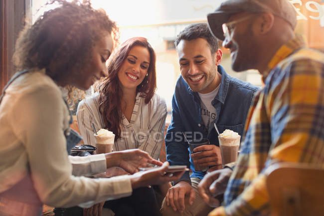 Young friends using digital tablet in cafe — Stock Photo