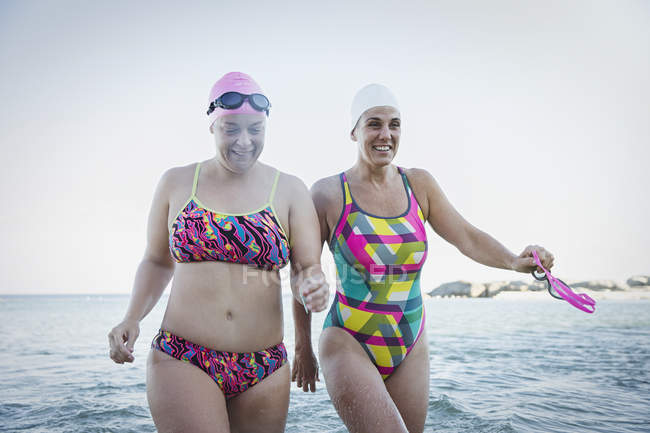 Mulheres nadadoras ativas caminhando no oceano ao ar livre — Fotografia de Stock