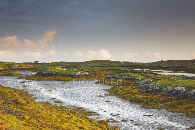 Vista tranquila de rocas escarpadas y agua, Harris, Hébridas Exteriores - foto de stock