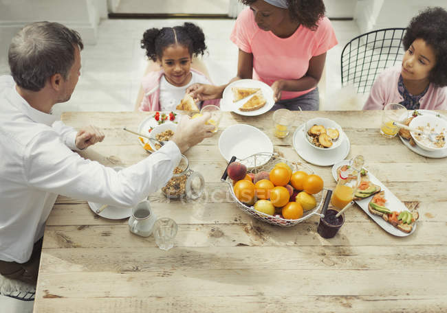 Multi-ethnic family eating breakfast at table — Stock Photo