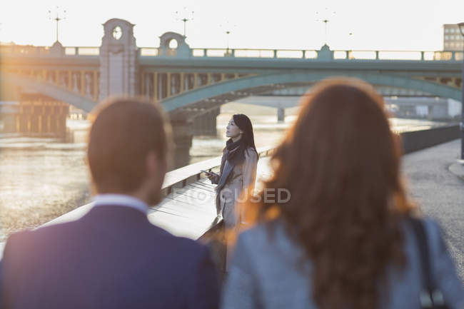 Businesswoman with cell phone at urban waterfront — Stock Photo