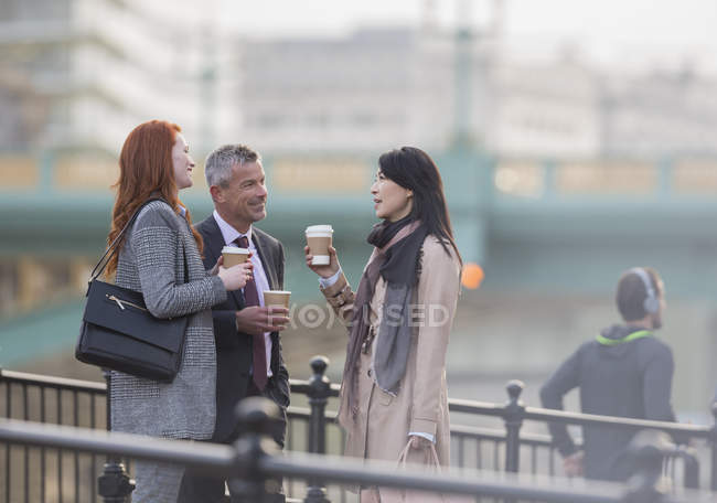 Gli uomini d'affari bevono caffè e parlano sulla rampa urbana — Foto stock