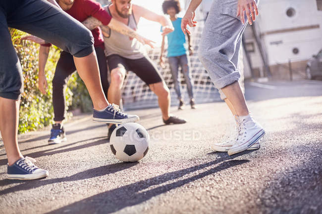 Amici che giocano a calcio in strada estate — Foto stock