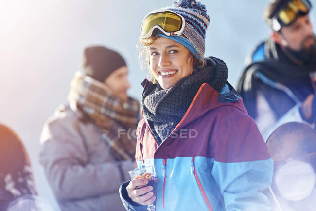 Портрет улыбающейся лыжницы, пьющей коктейль — стоковое фото