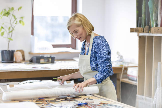 Artista de vidrieras revisando dibujos en estudio - foto de stock
