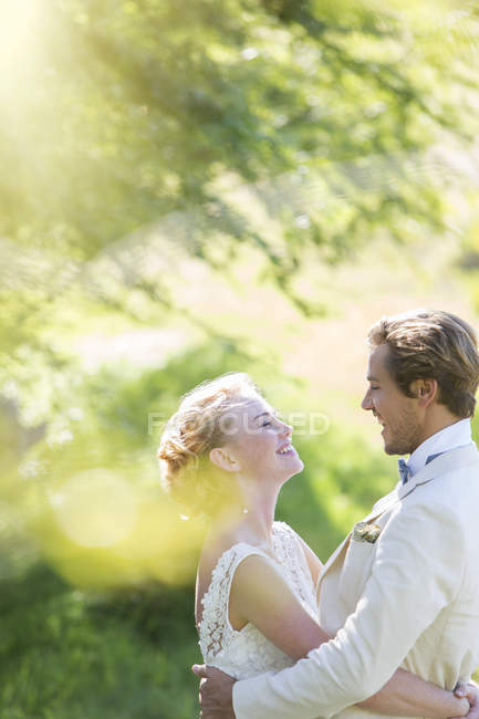Young smiling couple embracing in domestic garden — Stock Photo