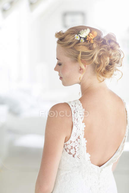 Young bride standing in sunny bedroom — Stock Photo