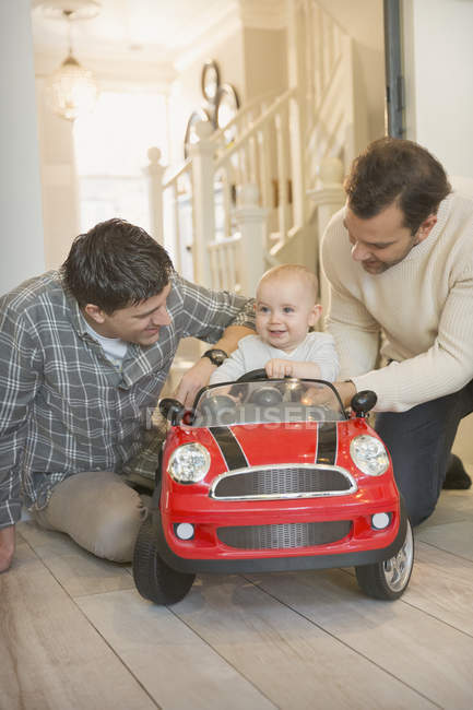 Чоловіки гей батьки і дитина син грають з іграшковою машиною — стокове фото