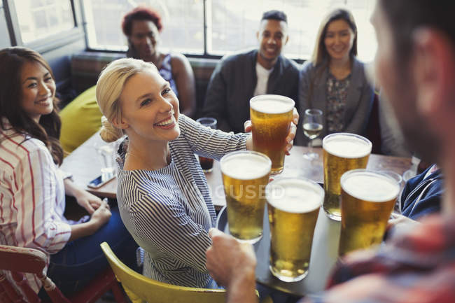 Cantinero sirviendo cervezas en bandeja a amigos en el bar - foto de stock