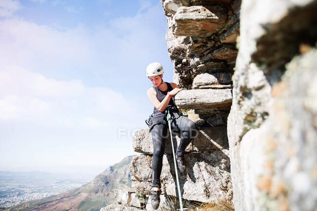 Жіночий альпініст, що звисає з каменю — стокове фото