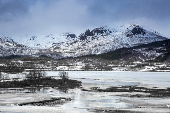 Tranquilas montañas cubiertas de nieve por encima del fiordo, Kavasen, Langoya, Vesteralen, Noruega - foto de stock
