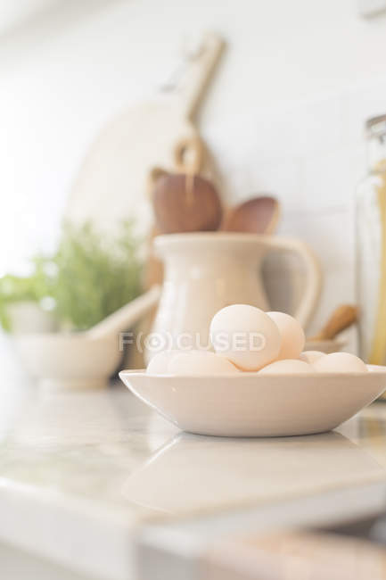 Натюрморт яйця в мисці на кухонній лічильнику — стокове фото