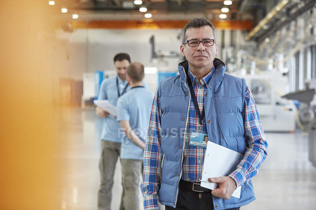 Retrato confiante supervisor masculino com área de transferência na fábrica — Fotografia de Stock