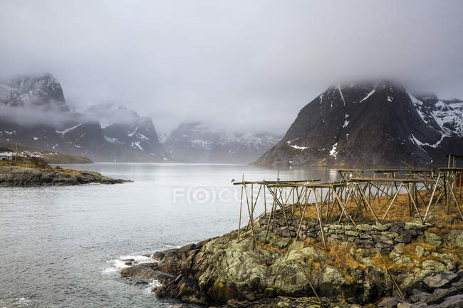 Niebla, montañas escarpadas y frías y río, Hamnoya, Lofoten, Noruega - foto de stock