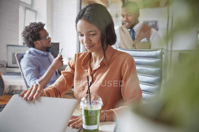 Бізнес-леді відкриває ноутбук, працює в офісі — стокове фото