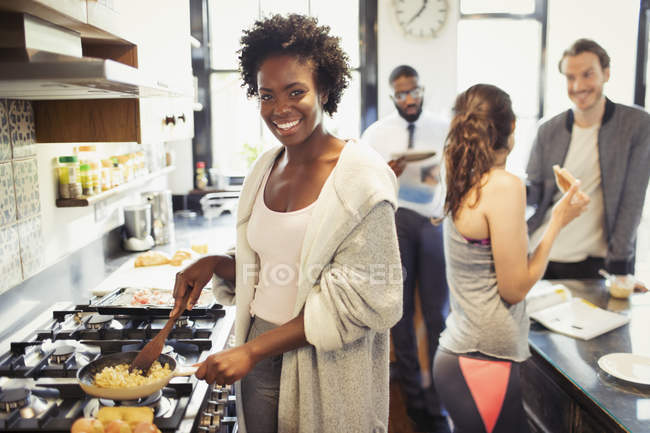 Retrato sorridente mulher cozinhar ovos mexidos no fogão na cozinha — Fotografia de Stock