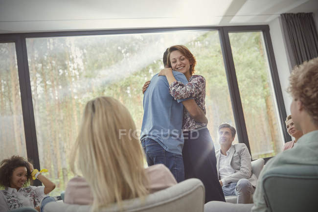 Homme et femme câlins dans la séance de thérapie de groupe — Photo de stock