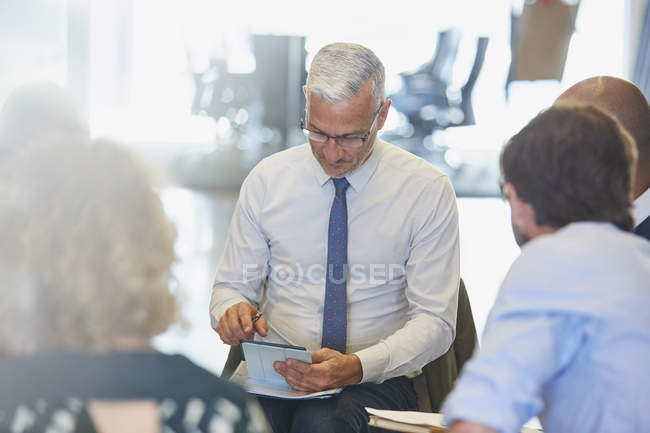 Homme d'affaires utilisant une tablette numérique dans une réunion au bureau moderne — Photo de stock