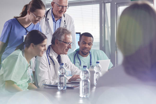 Reunión de cirujanos, médicos y enfermeras, utilizando laptop en la reunión del hospital - foto de stock