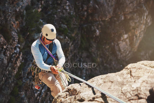 Male rock climber rappelling, descending from rope — Stock Photo