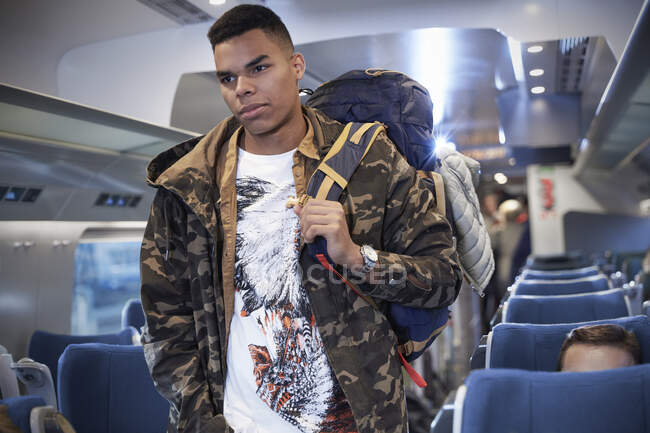 Young man with backpack boarding passenger train — Stock Photo