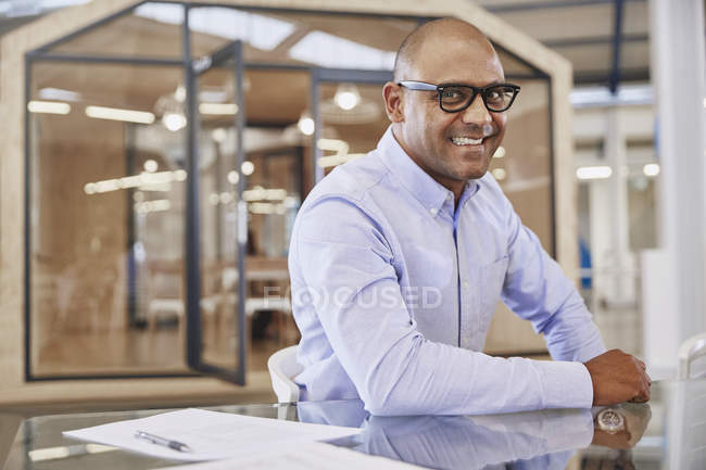 Portrait smiling businessman at modern office — Stock Photo