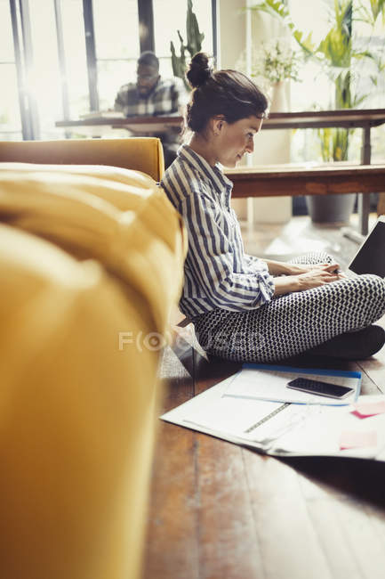 Жіночий фрілансер, що працює на ноутбуці на підлозі вітальні — стокове фото
