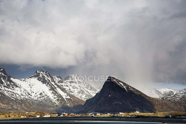 Dramáticas nubes sobre remotas montañas nevadas, Fredvang, Lofoten, Noruega - foto de stock