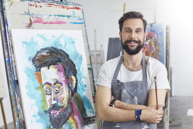 Портрет усміхнений, впевнений чоловічий живопис художника в художній студії — стокове фото