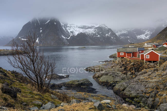 Village de pêcheurs au bord de l'eau sous la neige, montagnes escarpées, Hamnoya, Lofoten, Norvège — Photo de stock